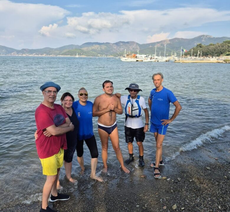 Partecipanti del progetto “Cambio di rotta” sorridenti sulla spiaggia di San Giovanni a Portoferraio
